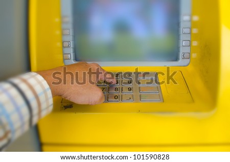 Finger pressing password number on Automatic Teller Machine