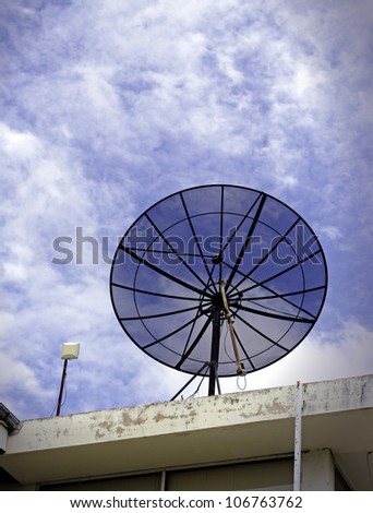 black satellite dish beside wireless network antenna on the roof of building