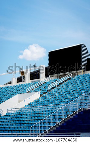 outdoor sport arena with black digital score board over stadium with blue seat