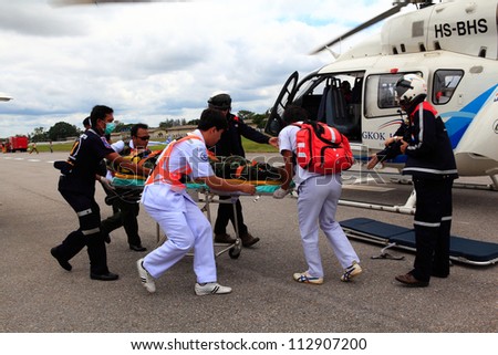Korat, Thailand - Sep 15 : Bangkok Hospital Rescue Team(White) Pulling Cart With Wounded Person To Helicopter In Search And Rescue Exercise(Sarex) On September 15, 2012 In Nakhonratchasima,Thailand