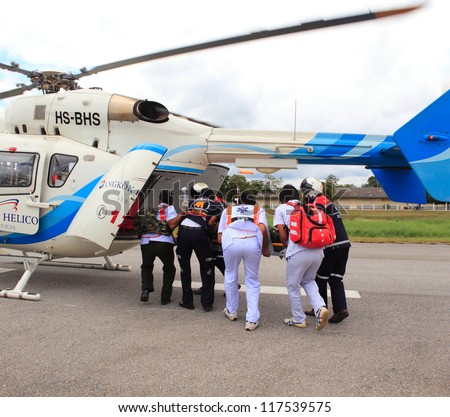 KORAT, THAILAND - SEP 15 : Bangkok Hospital Rescue team(white) pulling cart with wounded person to helicopter in Search and Rescue Exercise(SAREX) on September 15, 2012 in Nakhonratchasima,Thailand