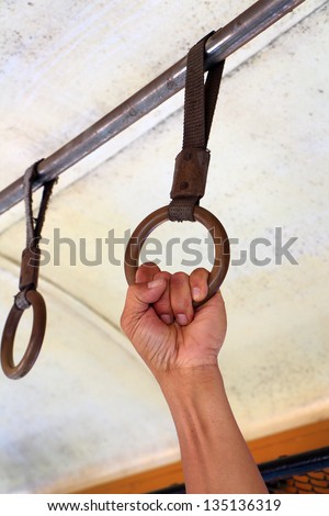 Male left hand grabbing on circle ring grip supported in train, Bangkok, Thailand.