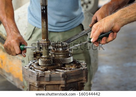 Mechanic man\'s hands examining car automobile at repair service station