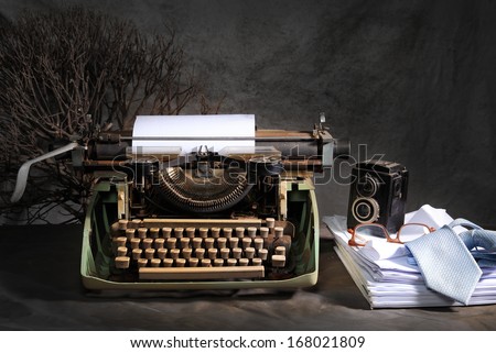 Vintage still life in reporter concept with old typewriter and retro twin lens reflex camera
