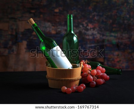 Still life art photography on old pale bottles with wine grape fruit and green ivy leaves
