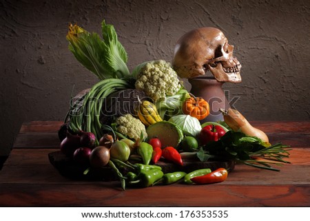 Still life art photography on raw mixed vegetables with skull