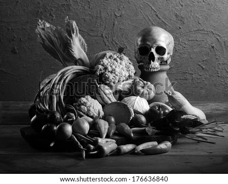 Still life art photography on raw mixed vegetables with skull black and white version with film grain