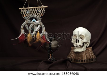 Still life art photography concept on skull dream catcher amulet brass vase and bead necklace
