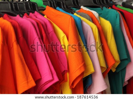 Colorful fashion t-shirts on hangers in the market