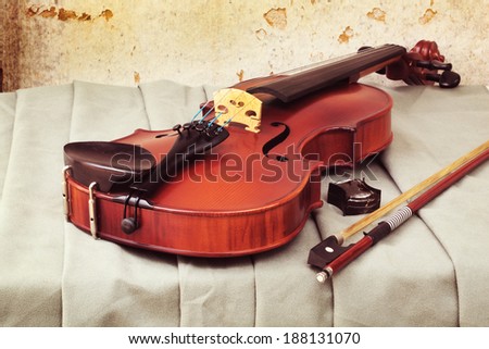 Still life art photography on resting violin bow and rosin on fabric with grunge background