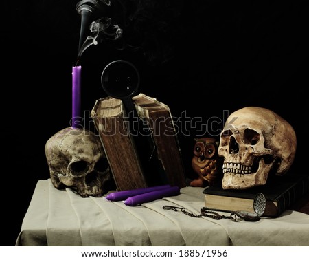 Still life art photography with skull on old book and candle on ruin skull