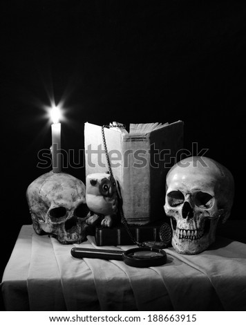 Still life art photography on academy concept with skull on old book and candle on ruin skull black and white version
