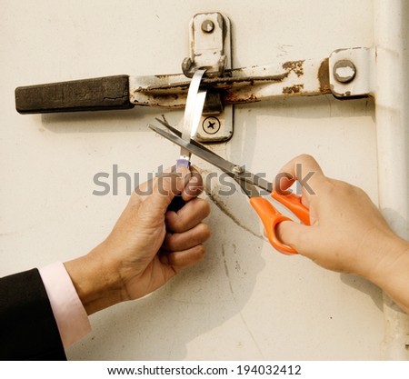 Business man and woman cutting aluminum protect seal of container door