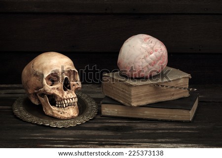 Still life art photography with skull and brass bowl and books