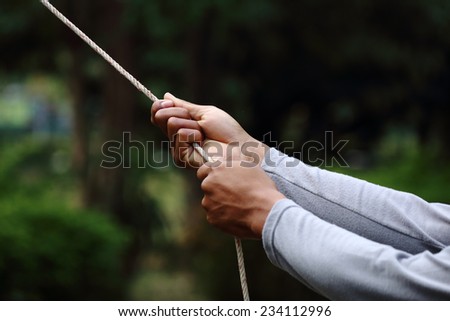 Male hands pulling rope a risk concept