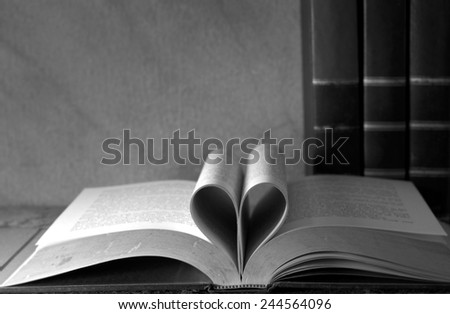 Vintage books and pages love heart sign on grunge sand stone table still life style black and white version
