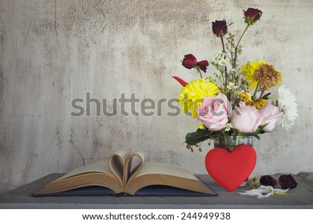 Still life art photography love concept with vintage book pages love heart sign on grunge