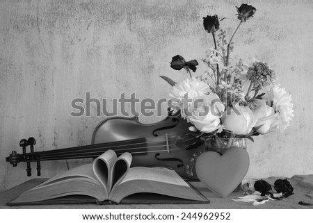 Vintage books and pages love heart sign with violin on grunge sand stone table still life style black and white version