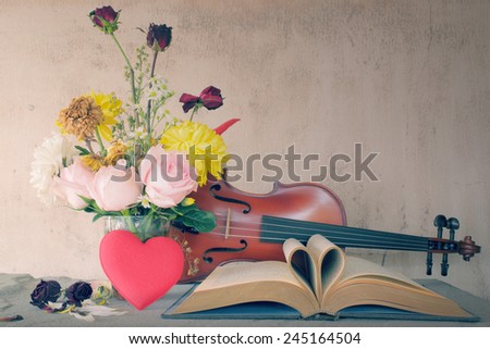 Vintage books and pages love heart sign with violin on grunge sand stone table still life style