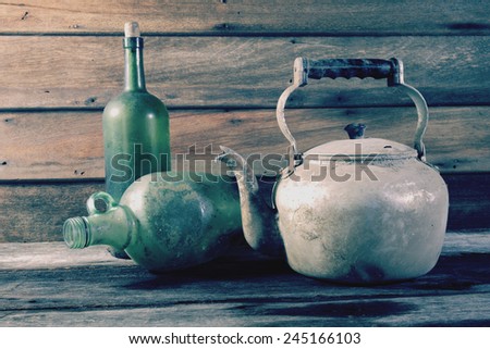 Still life art photography with old vintage kettle and muddy bottles