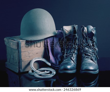 Still life art photography on vintage army helmet jungle boots and horseshoes