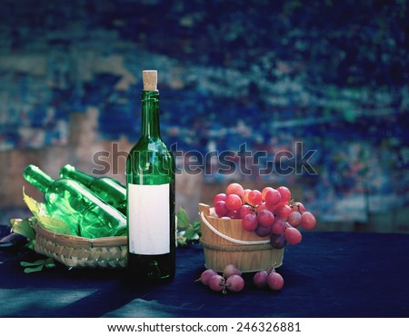 Still life art photography via day light on old pale bottles with wine grape fruit