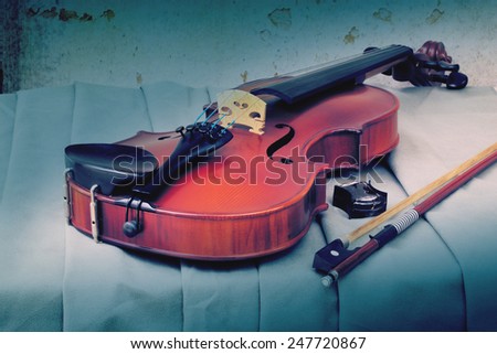 Still life art photography on resting violin bow and rosin on fabric with grunge background