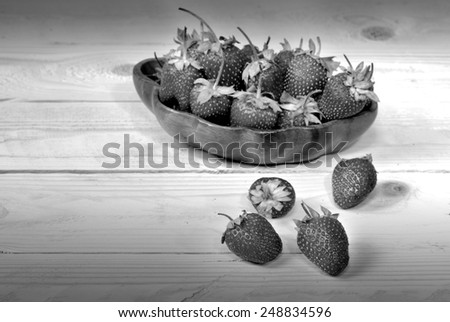 Strawberries in wood dish on wood floor and grunge still life style black and white version