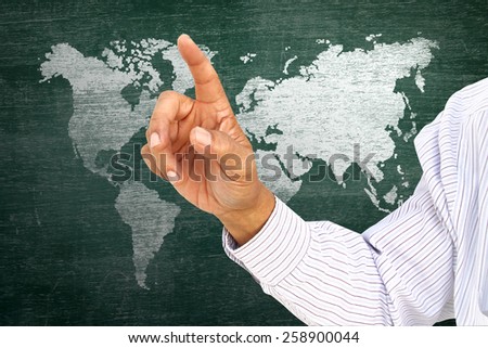 businessman pointing index on classroom media continents over green board