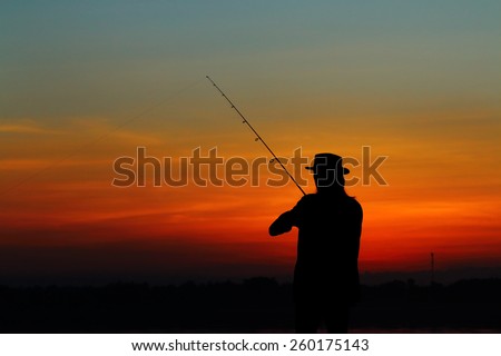 Fishing silhouette at the lake on sunset