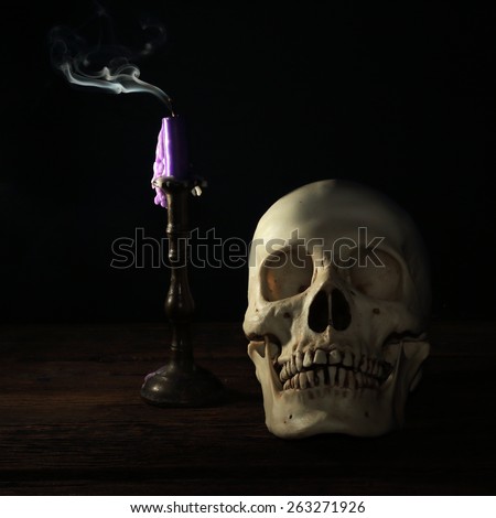 skull smoke candle on old wood floor death concept still life