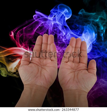 praying hands over misty smoke