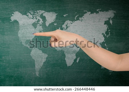 businesswoman hand pointing index on classroom media continents over green board