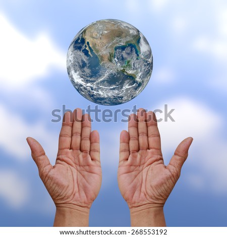 Human hands palm up with NASA global image as design element over blur cloud