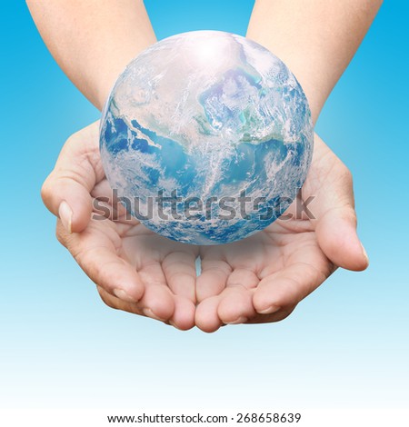 Human hands palm up with NASA global image as design element over blue shade