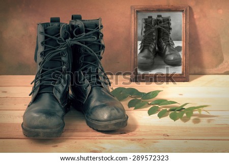 Still life art photography on jungle boots and monochrome wood frame