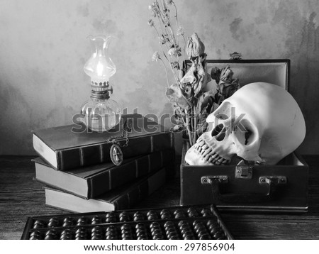 Still life art concept on human in box and properties with skull old book oil lantern abacus and Jesus Christ cross with necklace on old wood floor over grunge background hell black and white version