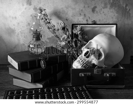 Still life art concept on human in box and properties with skull old book oil lantern abacus and Jesus Christ cross with necklace on old wood floor over grunge background hell black and white version