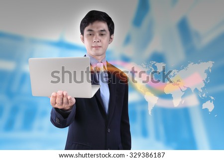 businessman holding laptop computer over blur office with imagine business line on global map