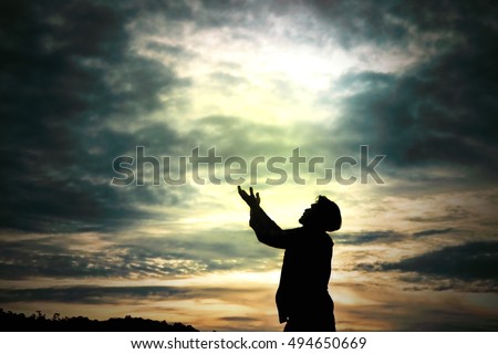Man standing prays for god in nature morning light