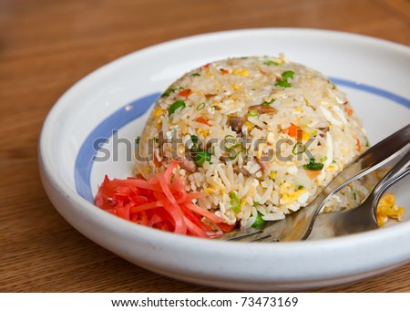 Japanese style fire rice in with plate on wood table.