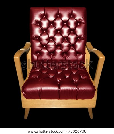Modern red comfortable armchair with solid wood legs and frame isolated on black.