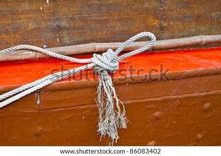 Tight rope knot on wood of ship; close up