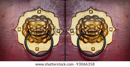Vintage door handle developing Chinese traditional golden head lion on red wood door