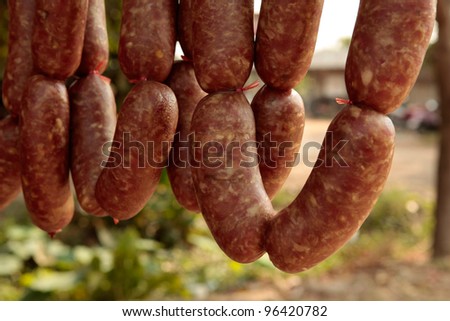Home made meat salami sausage at street market hanging in line under sunlight to make good tasty,Korat,Thailand.