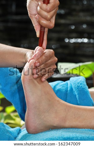 foot massage by wood stick for frontal sinuses