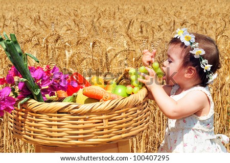 Little girl with basket of the first fruits during the Jewish holiday, Shavuot in Israel.