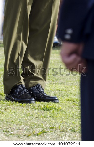Lower body of a shiny army shoes and brown uniform during military parade.