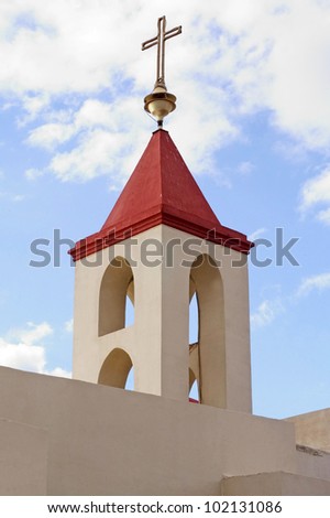 The bell tower and cross of  St. John Church in Acre Akko, Israel.