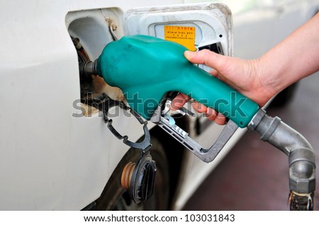 A person fuel his vehicle in a fueling station.